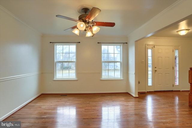 foyer featuring wood-type flooring, a healthy amount of sunlight, and crown molding