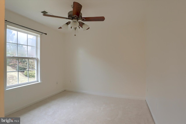 empty room featuring baseboards and light colored carpet