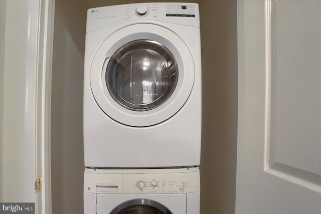 washroom featuring stacked washer and dryer and laundry area