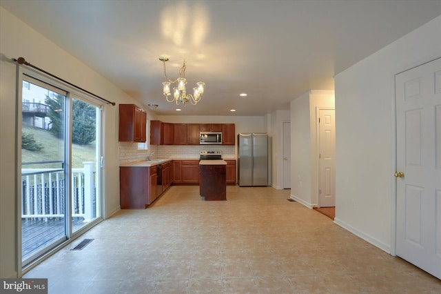 kitchen featuring a notable chandelier, stainless steel appliances, tasteful backsplash, light countertops, and visible vents