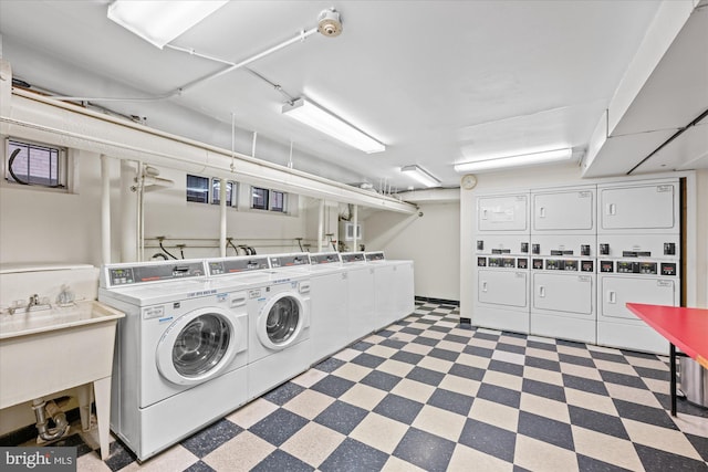 shared laundry area with stacked washer and dryer, washer and clothes dryer, and a sink