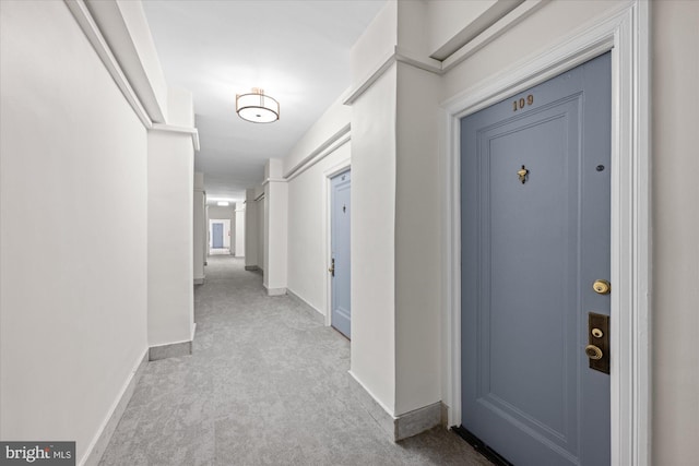 hall with carpet floors and baseboards