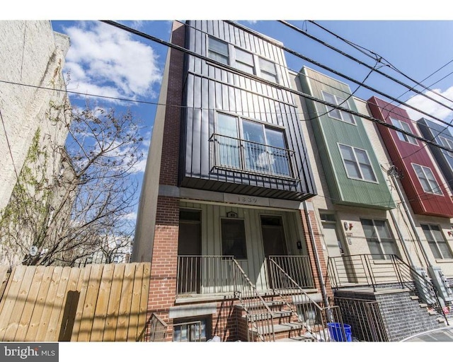 multi unit property featuring a porch and brick siding