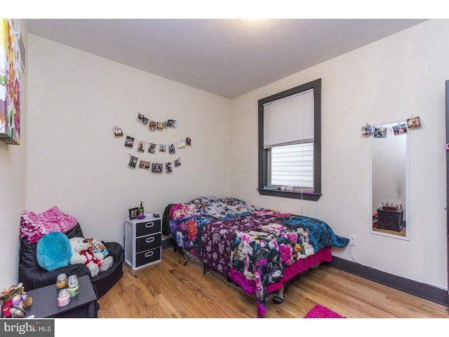 bedroom featuring baseboards and wood finished floors