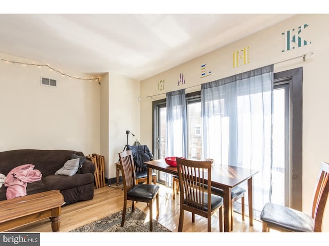 dining space with radiator, visible vents, and light wood finished floors