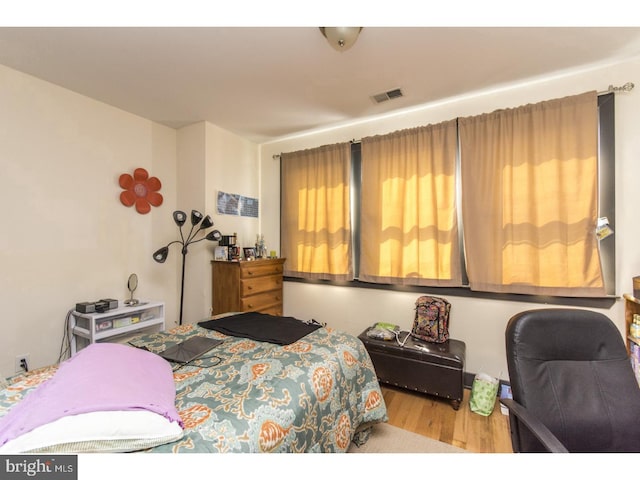 bedroom with visible vents and wood finished floors