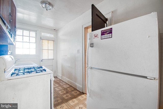 kitchen featuring white appliances, baseboards, and light floors