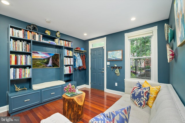 living area featuring baseboards, dark wood-type flooring, and recessed lighting