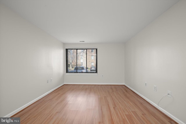 unfurnished room with light wood-style flooring and baseboards