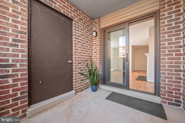 view of exterior entry featuring brick siding