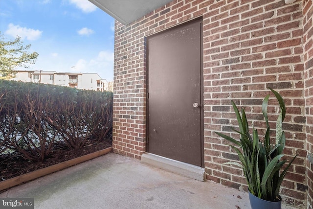 doorway to property with brick siding