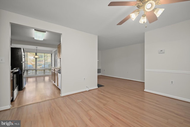 spare room featuring a ceiling fan, baseboards, visible vents, and light wood finished floors