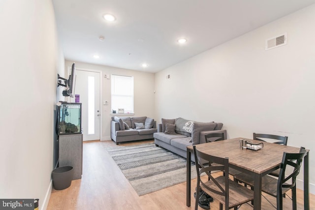 living area with baseboards, light wood finished floors, visible vents, and recessed lighting