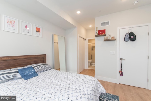 bedroom with recessed lighting, visible vents, ensuite bathroom, wood finished floors, and baseboards