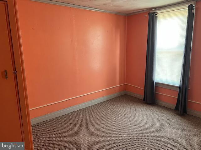 carpeted spare room featuring a wealth of natural light and baseboards