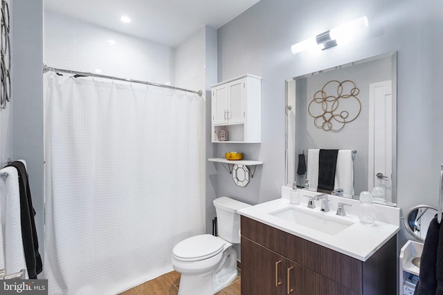 full bathroom with wood finished floors, curtained shower, vanity, and toilet