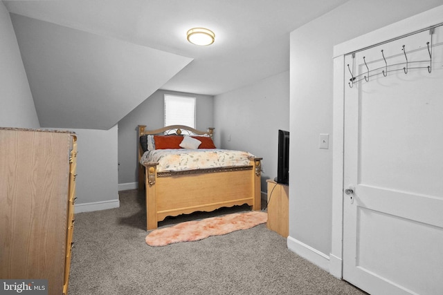 bedroom featuring lofted ceiling, carpet floors, and baseboards