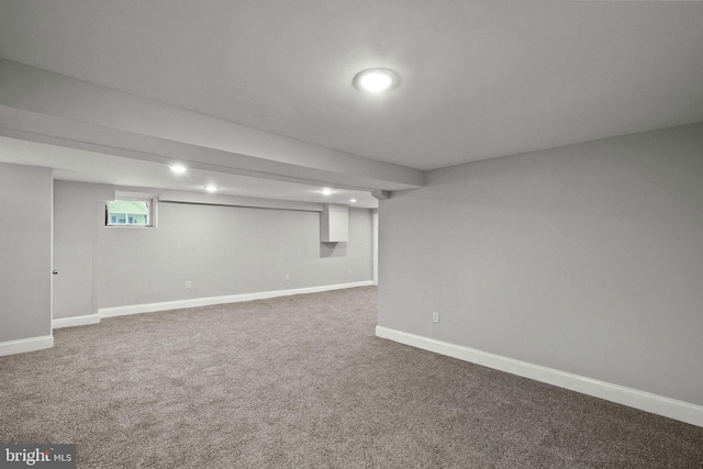 below grade area featuring carpet flooring and baseboards