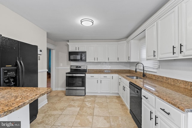 kitchen featuring light tile patterned floors, backsplash, white cabinetry, a sink, and black appliances