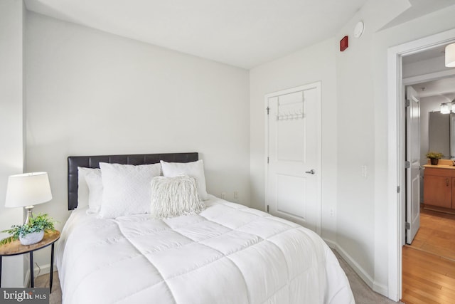 bedroom with light wood-style floors and baseboards