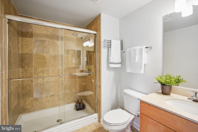 bathroom with a stall shower, vanity, and toilet