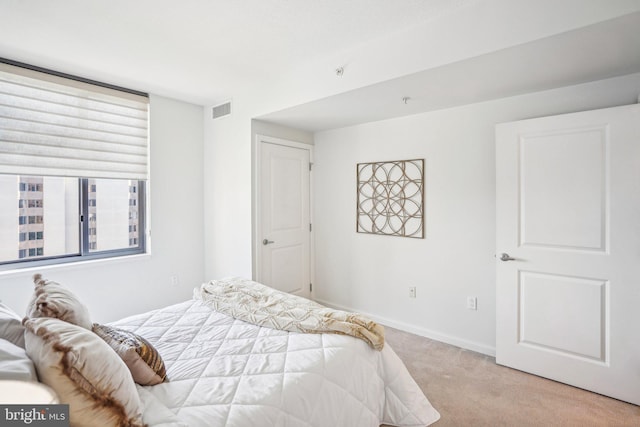 bedroom featuring baseboards, visible vents, and light colored carpet