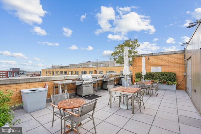 view of patio / terrace with outdoor dining area, an outdoor kitchen, and a sink