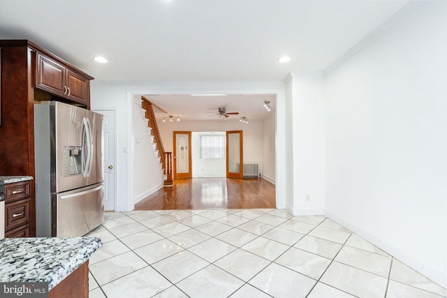 kitchen featuring light tile patterned floors, baseboards, radiator, crown molding, and stainless steel refrigerator with ice dispenser