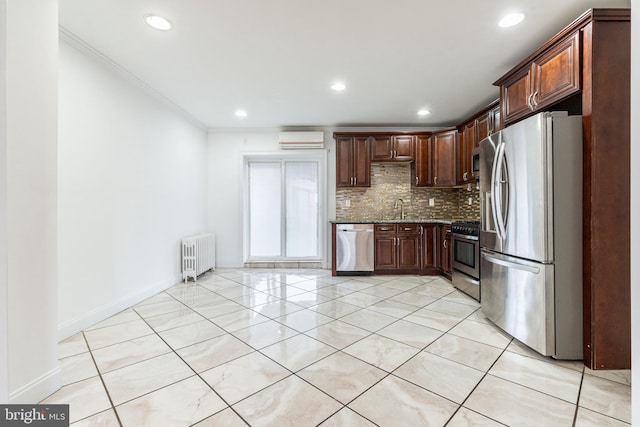 kitchen featuring tasteful backsplash, radiator, appliances with stainless steel finishes, a sink, and a wall mounted AC