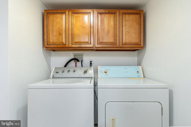 washroom featuring washing machine and dryer and cabinet space