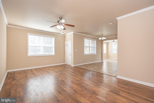 empty room with ceiling fan, baseboards, hardwood / wood-style floors, and crown molding