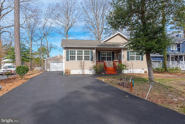 view of front facade with driveway, a detached garage, a porch, a shingled roof, and crawl space