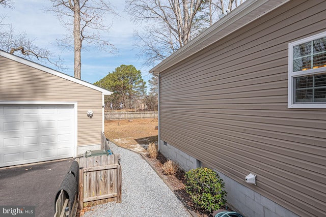 view of home's exterior with a garage and an outbuilding