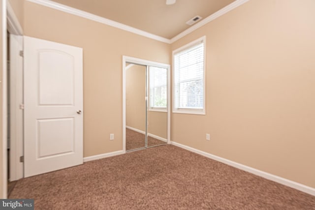 unfurnished bedroom with crown molding, carpet, visible vents, and baseboards