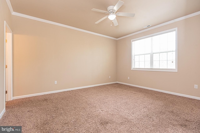 carpeted empty room featuring a ceiling fan, visible vents, baseboards, and ornamental molding