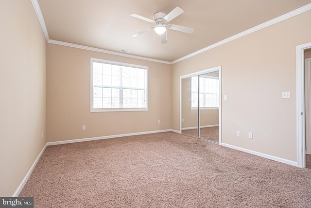 unfurnished bedroom with visible vents, baseboards, ornamental molding, a closet, and carpet flooring