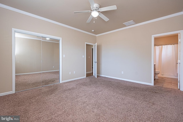 unfurnished bedroom with a closet, ornamental molding, baseboards, and carpet floors