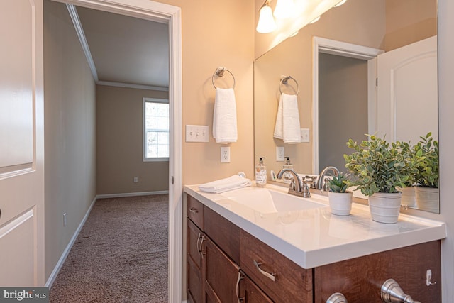 bathroom with baseboards, ornamental molding, and vanity