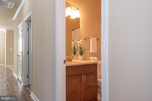 full bath featuring visible vents, crown molding, toilet, wood finished floors, and vanity