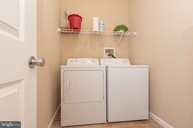 washroom featuring laundry area, light tile patterned flooring, baseboards, and independent washer and dryer