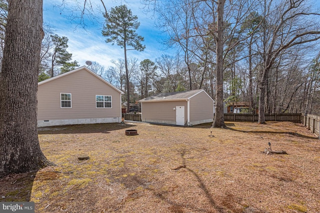 view of yard with an outbuilding, fence private yard, and an outdoor fire pit