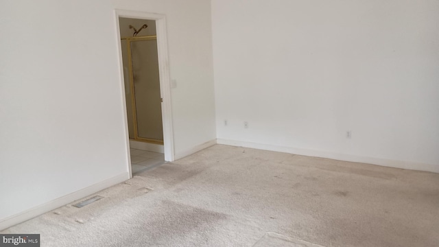 unfurnished room featuring carpet floors, visible vents, and baseboards