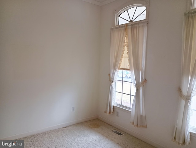 spare room featuring carpet flooring, visible vents, and baseboards