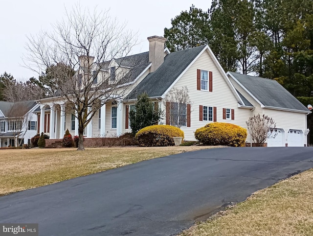 exterior space with a chimney, a yard, and driveway