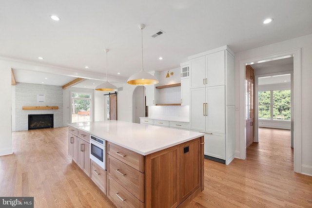 kitchen with visible vents, backsplash, oven, light wood-style flooring, and open shelves