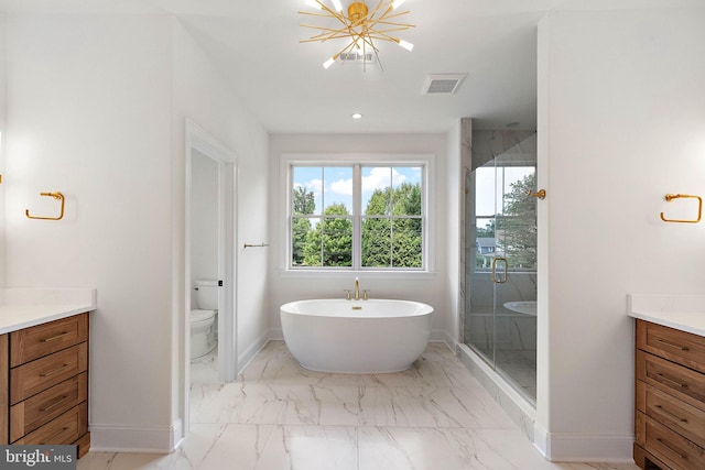 bathroom with vanity, baseboards, a stall shower, a freestanding bath, and marble finish floor