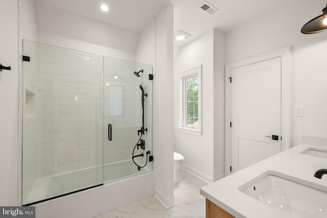 full bath featuring visible vents, toilet, double vanity, marble finish floor, and a sink