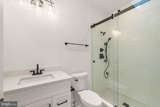 bathroom featuring toilet, a stall shower, and vanity