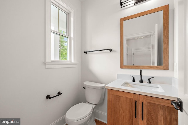 bathroom with vanity, toilet, and baseboards