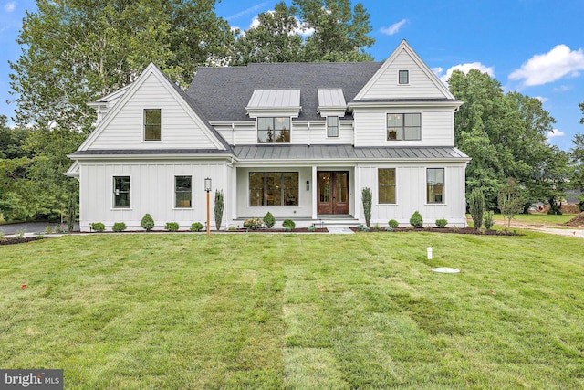 modern farmhouse style home featuring metal roof, board and batten siding, a front lawn, and a standing seam roof